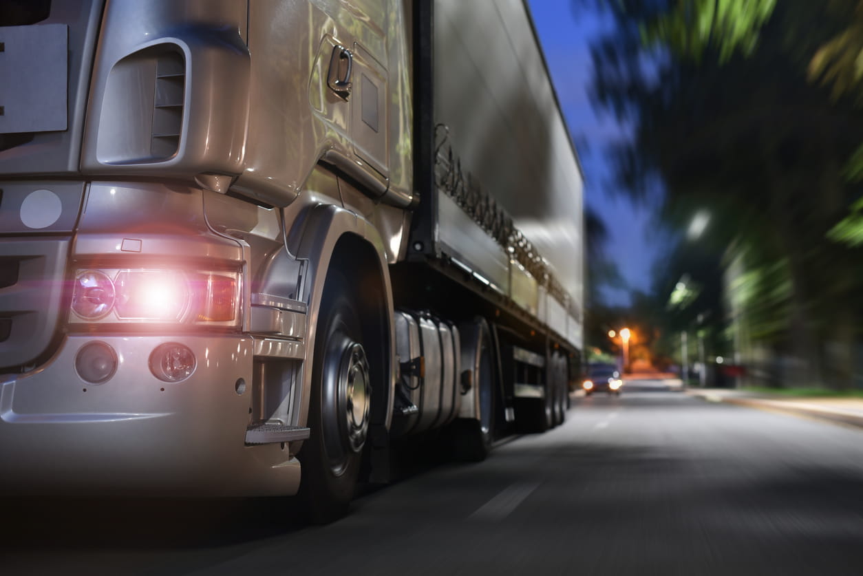 commercial truck coasts down the road at night