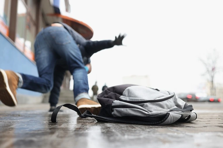 Close-up of a person getting injured after falling on slippery ground in the winter season. Accident, trauma.